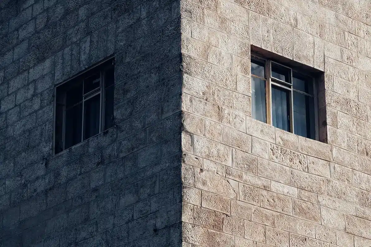 Historic mansion exterior in bright daylight with trees and stone steps