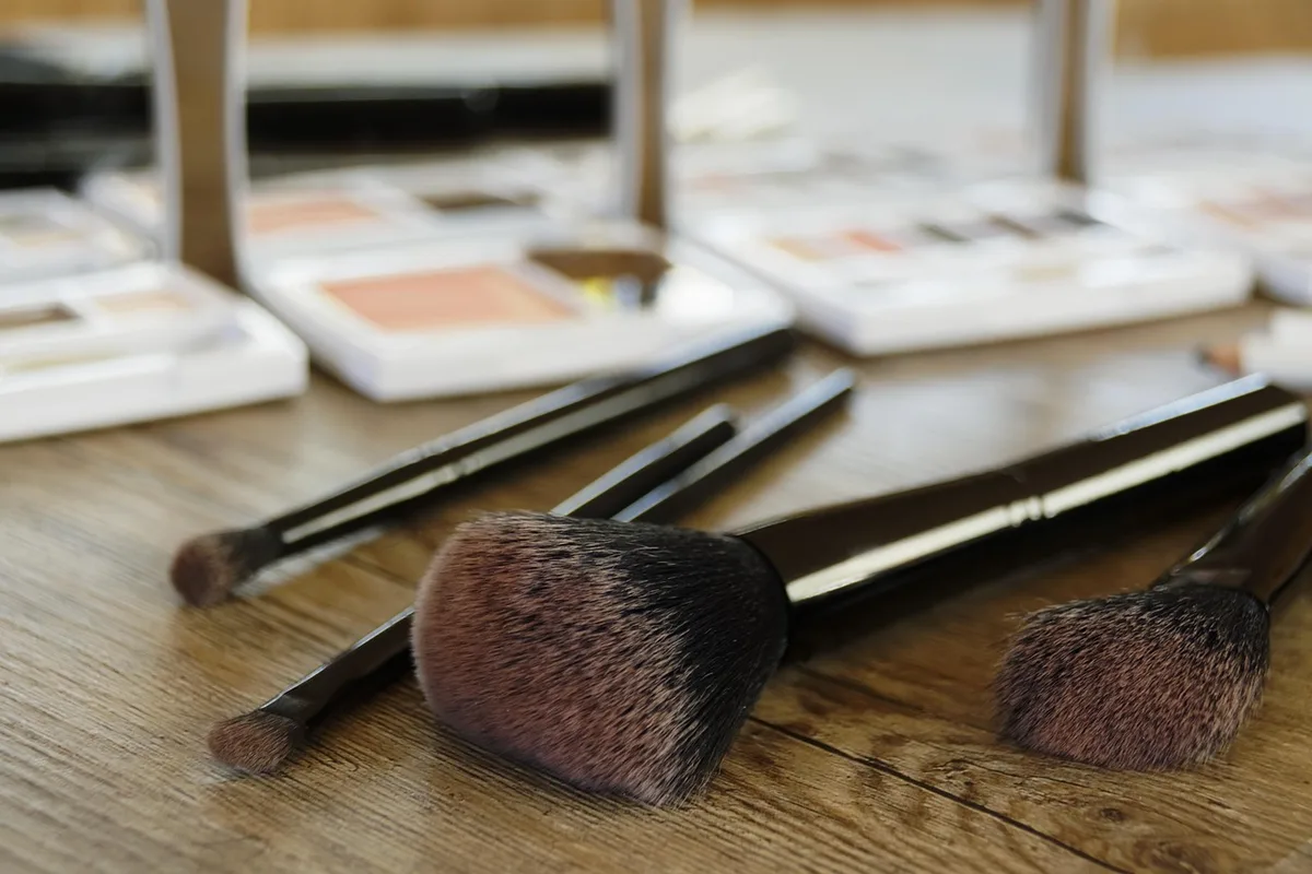 Makeup workstation with prosthetics, brushes and sketches on a sunlit table