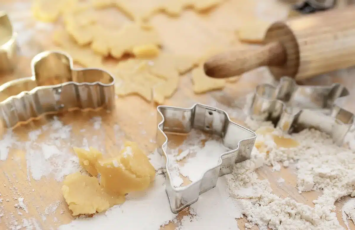 Slicing a chilled shortbread dough log on parchment