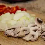 Bright supermarket deli counter with hands choosing festive prepared dishes